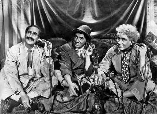 a photo of Chico, Harpo, and Groucho Marx from 1946 all using telephones from the period