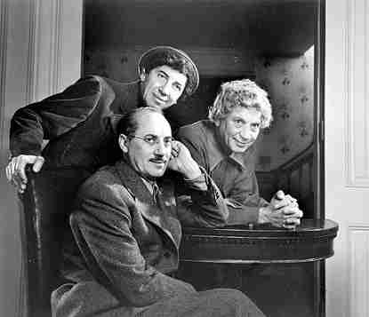 a photo of Chico, Harpo, and Groucho Marx at a desk from 1948